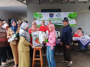 Kasi Ekbang Kelurahan Mekarjaya,Ibu Sukaesih saat menyerahkan media tanam kepada siswi yang hadir