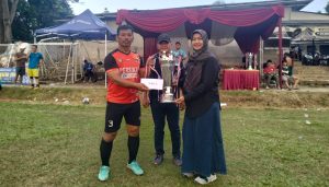 Keterangan Foto : Lurah Mekarjaya Dra. Nelda Purnadia Wardhani saat memberikan piala juara kedua kepada kapten tim Persikas Sukmajaya