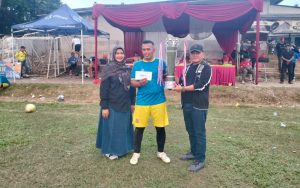 Keterangan Foto : Kapten Tim Mekarjaya FC saat menerima Piala juara pertama dari H.Yahman setiawan kanan, di dampingi Lurah Mekarjaya Dra. Nelda Purnadia Wardhani kiri