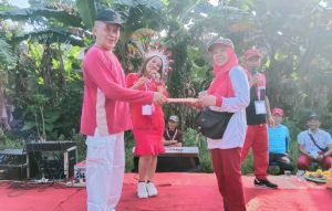 Ketua RW 09 Sukmajaya, Bambang Haryoto saat memberikan hadiah doorprize kepada warga